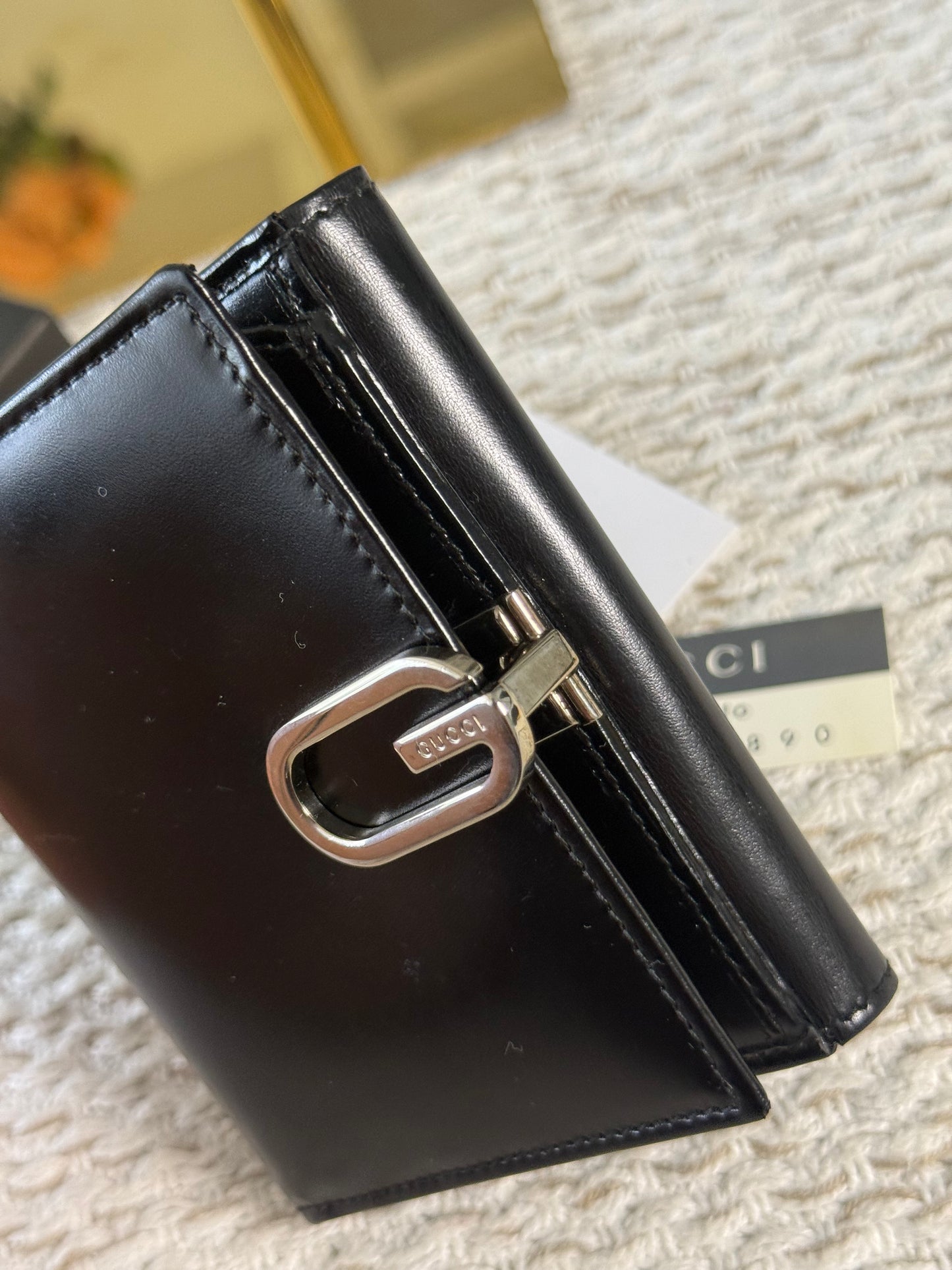 GUCCI SMOOTH BLACK LEATHER BI-FOLD WALLET WITH A SILVER-TONE “G” CLASP