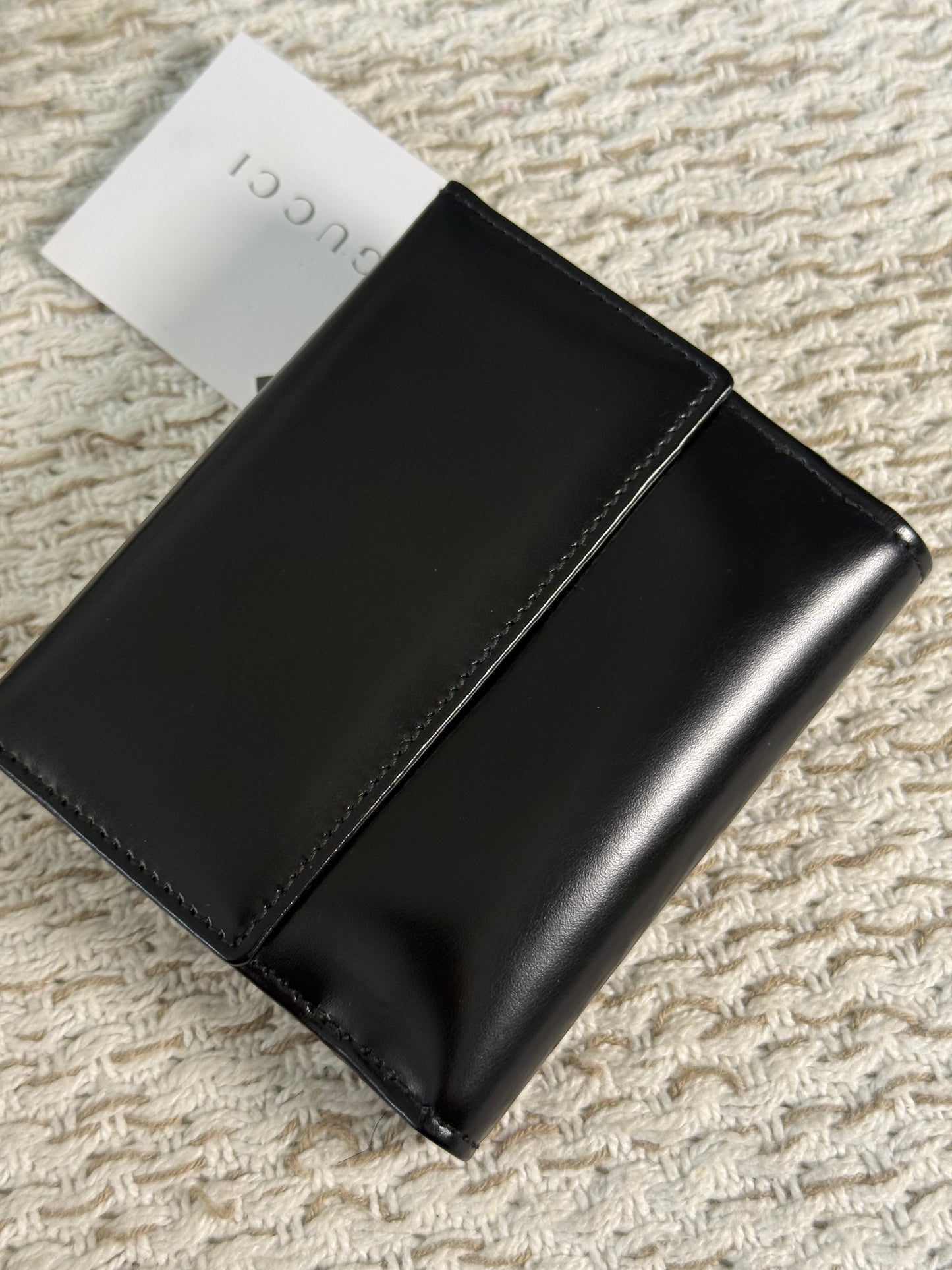 GUCCI SMOOTH BLACK LEATHER BI-FOLD WALLET WITH A SILVER-TONE “G” CLASP