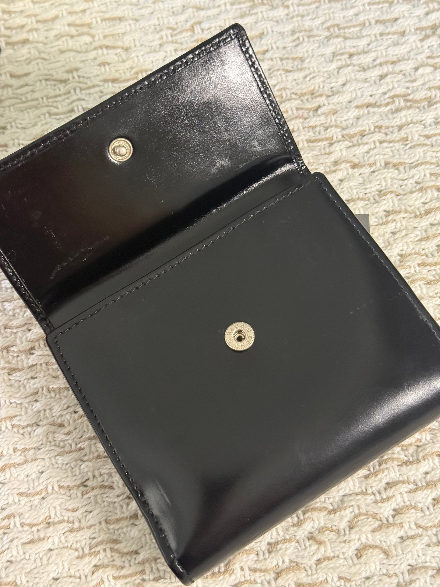 GUCCI SMOOTH BLACK LEATHER BI-FOLD WALLET WITH A SILVER-TONE “G” CLASP
