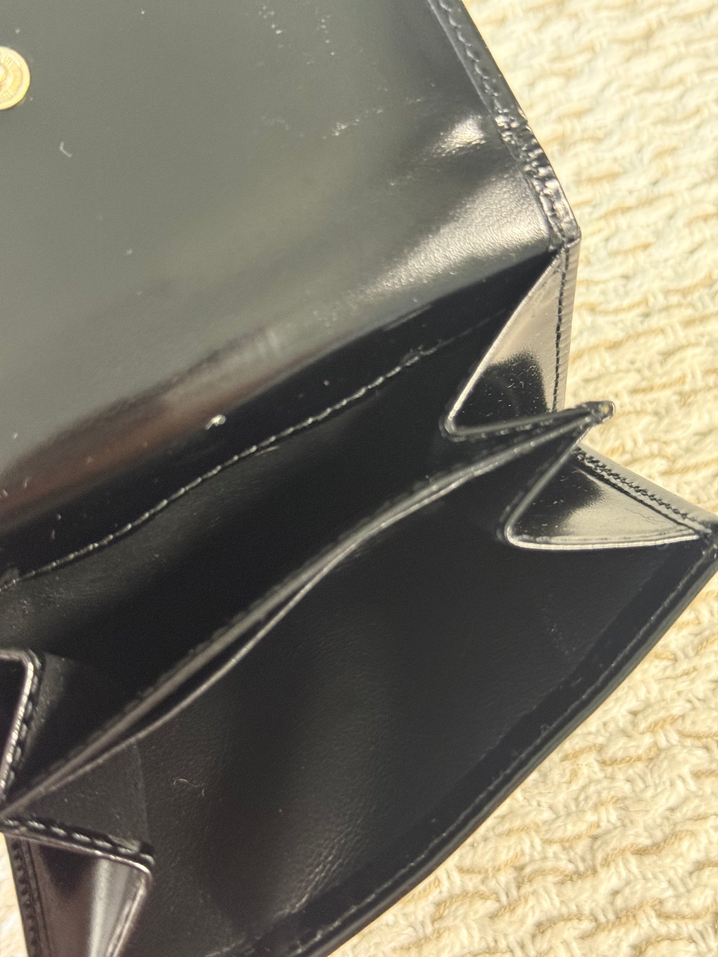 GUCCI SMOOTH BLACK LEATHER BI-FOLD WALLET WITH A SILVER-TONE “G” CLASP