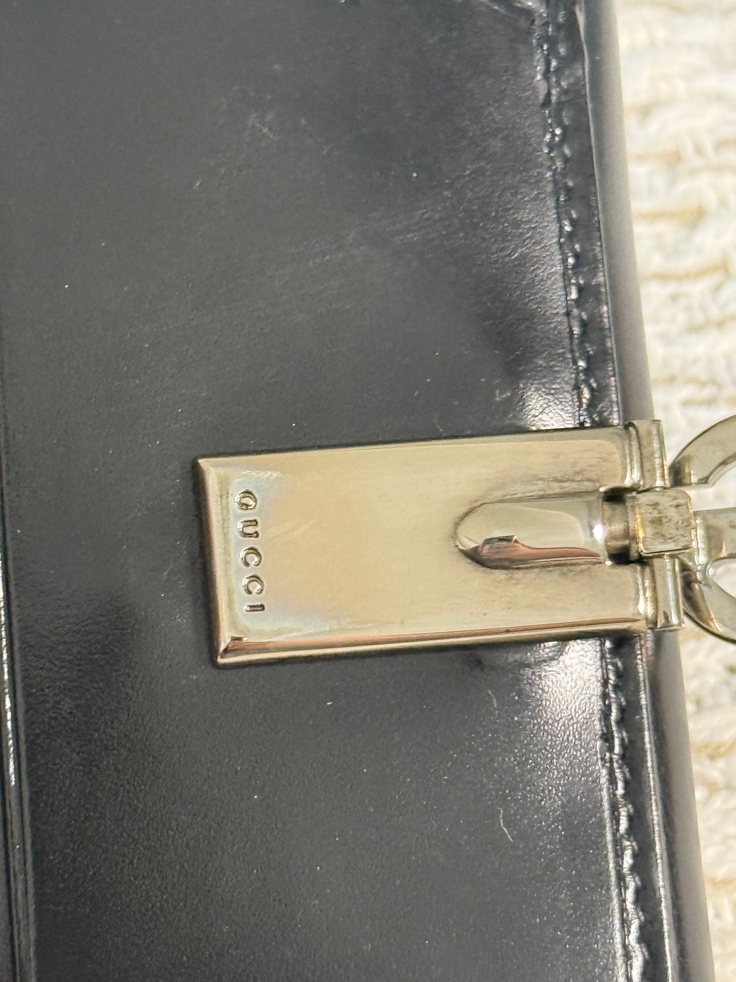 GUCCI SMOOTH BLACK LEATHER BI-FOLD WALLET WITH A SILVER-TONE “G” CLASP