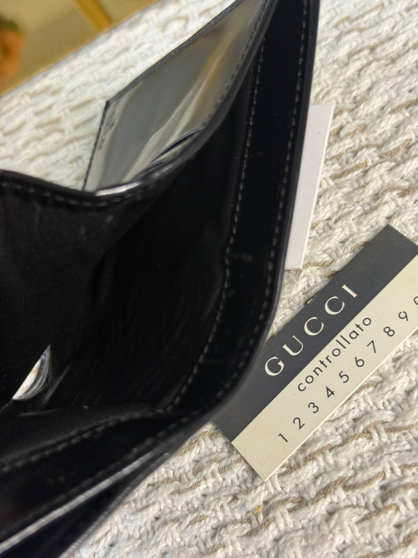 GUCCI SMOOTH BLACK LEATHER BI-FOLD WALLET WITH A SILVER-TONE “G” CLASP